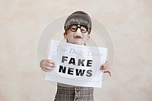 Newsboy shouting against grunge wall background. Boy selling fake news