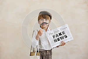 Newsboy shouting against grunge wall background. Boy selling fake news