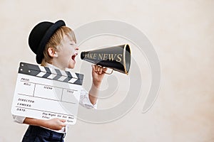 Newsboy shouting against grunge wall background. Boy selling fake news