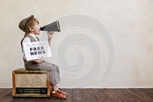 Newsboy shouting against grunge wall background. Boy selling fake news