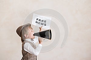 Newsboy shouting against grunge wall background. Boy selling fake news