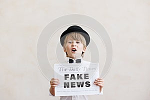 Newsboy shouting against grunge wall background. Boy selling fake news