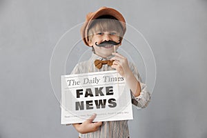 Newsboy shouting against grunge wall background. Boy selling fake news