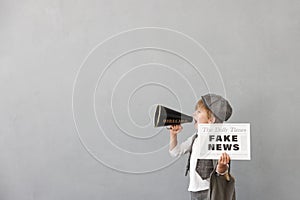 Newsboy shouting against grunge wall background. Boy selling fake news