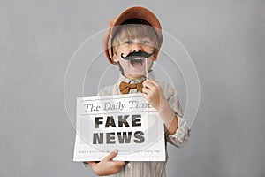 Newsboy shouting against grunge wall background. Boy selling fake news