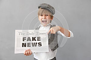 Newsboy shouting against grunge wall background. Boy selling fake news