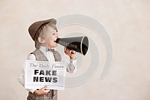 Newsboy shouting against grunge wall background. Boy selling fake news