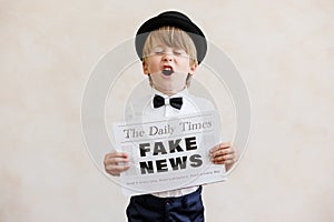 Newsboy shouting against grunge wall background. Boy selling fake news