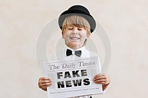 Newsboy shouting against grunge wall background. Boy selling fake news