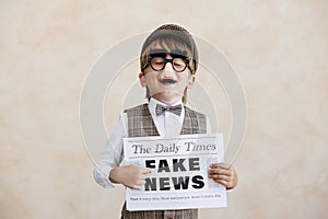 Newsboy shouting against grunge wall background. Boy selling fake news