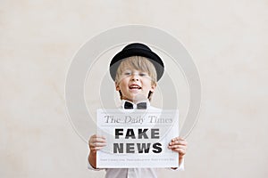 Newsboy shouting against grunge wall background. Boy selling fake news