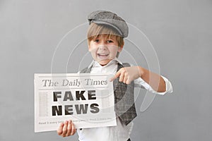 Newsboy shouting against grunge wall background. Boy selling fake news photo