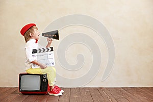 Newsboy shouting against grunge wall background. Boy selling newspaper