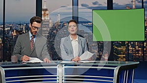 Newscasters broadcasting green screen news late studio closeup. Anchors talking