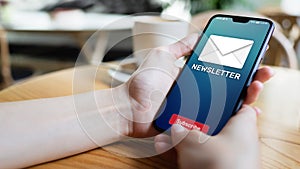 Newsletter subscription button on mobile phone screen. Business marketing concept.