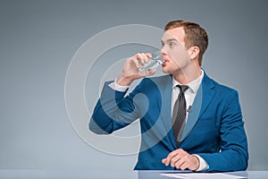 Newsman drinking water at his desk