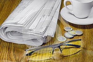 Newspaper cup of coffee and glasses on the table