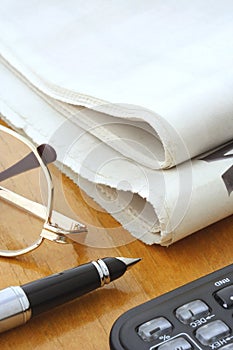 Newspaper, Glasses, Pen and Calculator