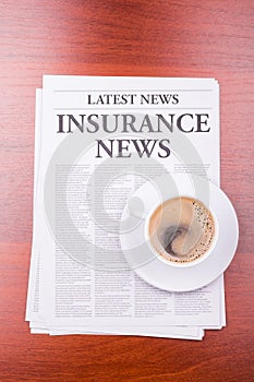 The newspaper INSURANCE NEWS and coffee