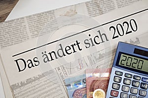 Newspaper with money and calculator and german headline Changes coming in 2020 - das Ã¤ndert sich 2020