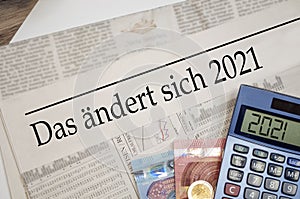 Newspaper with money and calculator and german headline Changes coming in 2021 - das Ã¤ndert sich 2020