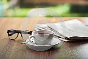 Newspaper reading glasses coffee cup