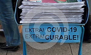 Newspaper stack with shout out covid-19 virus curable