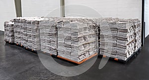 Newspaper stacks on pallets in warehouse