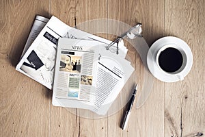 Newspaper with tablet on wooden table