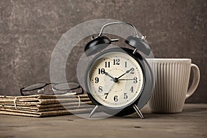 Newspapers, glasses, alarm clock and coffee cup on desktop