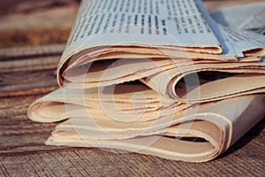 Newspapers on old wood background. Toned image.