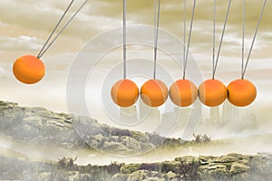 Newtons cradle above city in mountains