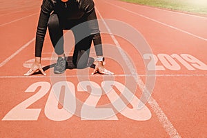 2020 Newyear , Athlete Woman starting on line for start running with number 2020 Start to new year