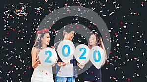 Newyear party ,celebration party group of asian young people holding balloon numbers 2020 happy and funny concept