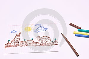Next to the markers is a primitive children`s drawing with a felt-tip pen on a white background. child development