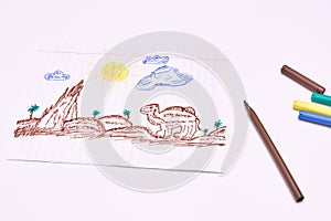 Next to the markers is a primitive children`s drawing with a felt-tip pen on a white background. child development