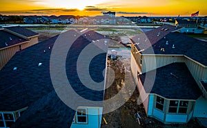 Next to Modern Rooftops Orange Horizon Sunset sun beams across new development construction Suburb