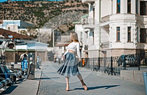 Fashion lifestyle portrait of young happy pretty woman laughing and having fun on the street at nice sunny summer day