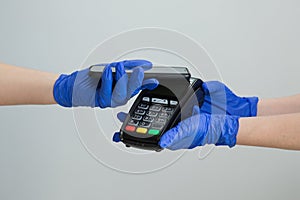 Nfc cellhone of female buyer with cashless wallet of e-money for pos card reader and checkout. Woman in gloves applies