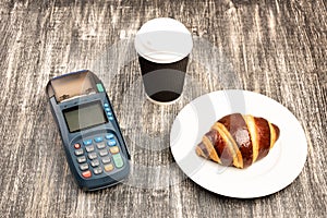 NFC payment terminal and take away cup of coffee