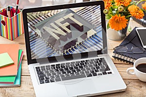 NFT Non Fungible Token text on laptop screen, office background