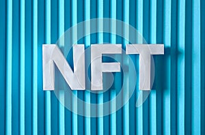 NFT text letters on a blue background. Minimal is the concept of digital modern technologies of crypto tokens and sales