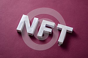 NFT text on a red background diagonally as a concept of modern technologies of online