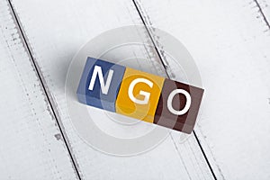 NGO acronym for Non-Governmental Organization on colorful wooden cube.