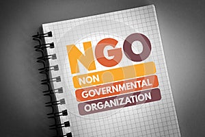 NGO - Non-Governmental Organization acronym on notepad, business concept background photo