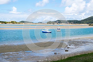 Ngunguru Harbour at low tide with boats moored in the river estuary near the sandspit - in Northland, New Zealand, NZ