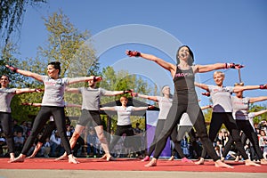 Dynamic Piloxing Training: Energetic Group with Instructor in Black T-Shirt and Microphone
