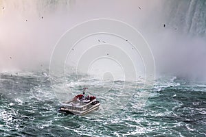 Niagara Falls in Canada. A cruise boat with tourists approaching the Horseshoe Falls.
