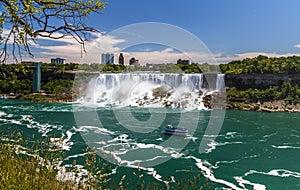 Niagara Falls, looking down the Niagara river. View of the river, observation tower, watefalls, cruise boats, city skyline.