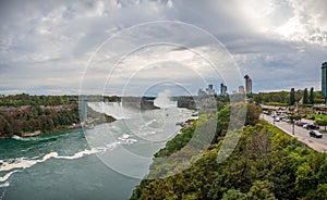 Niagara Falls, New York and Canada [ edge of Niagara falls, town from American and Canadian city side, falling water and mist ]